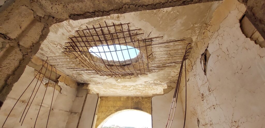 Figure 4. Structural Damage in the First-Floor Slab Showing Large Openings and Exposed Reinforcement